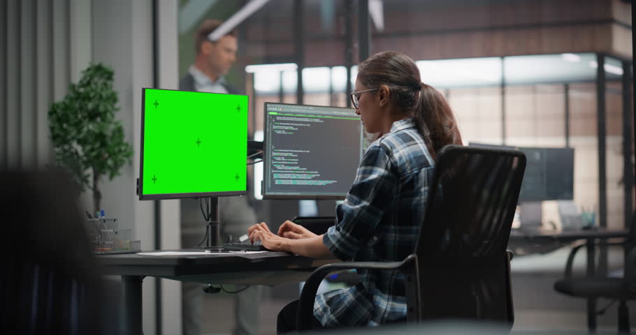 Female Software Developer Working on Desktop Computer with Green Screen Chroma Key Template, Writing Code and Managing Projects for a Corporate IT Partner. Girl Sitting with Her Back to Camera