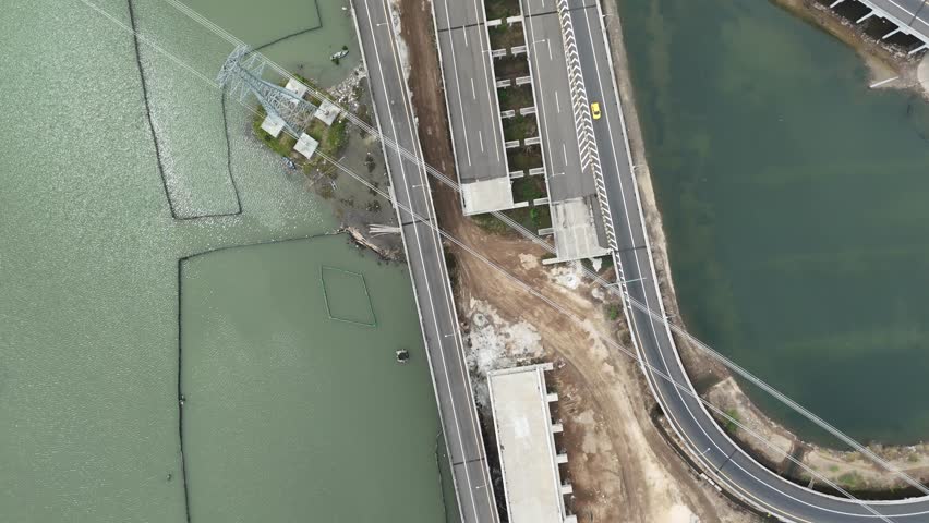 Aerial View Displays a Serene Landscape with Roads, Waterways, and Vehicles