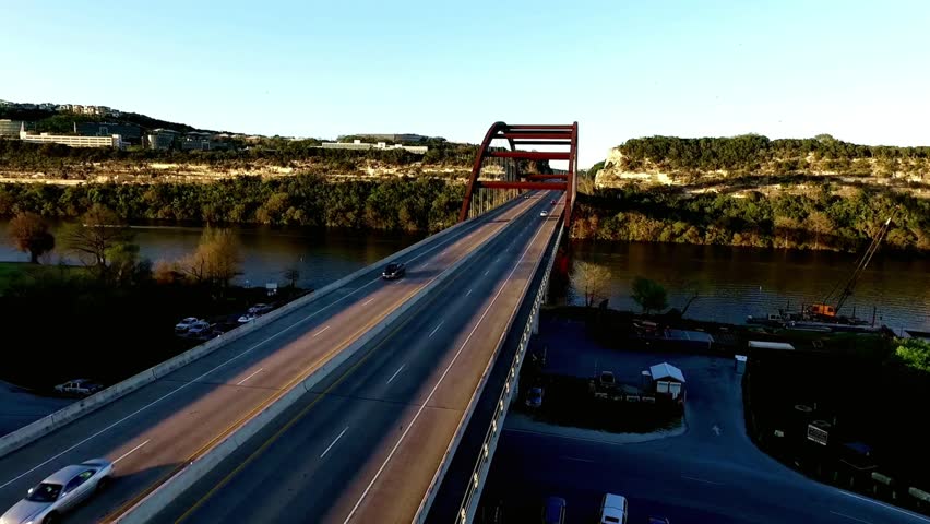 Pennybacker bridge in austin texas with a car crossing the bridge at sunset