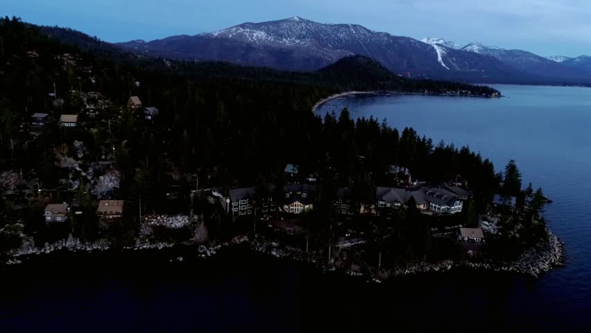Aerial view of lake tahoe shoreline with houses and snow capped mountains