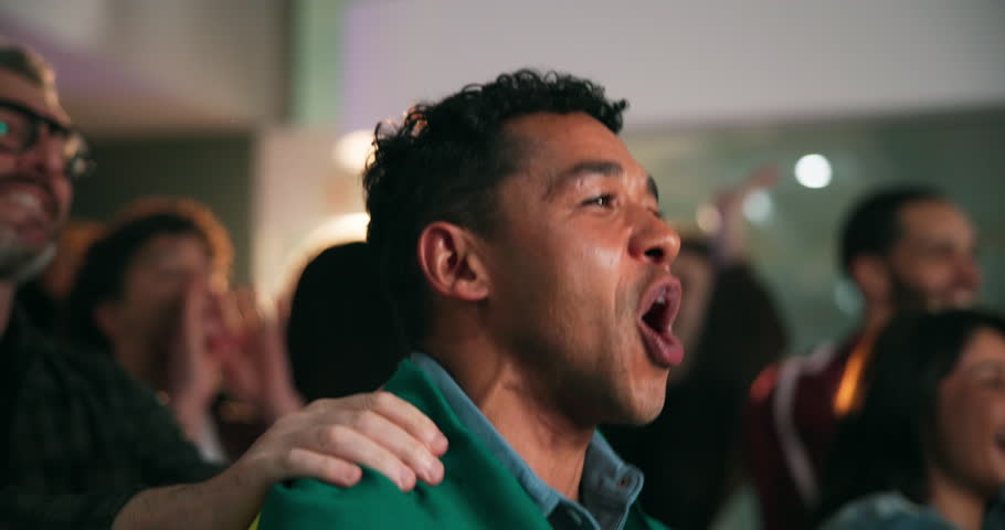 Men, celebration and flag for goal at sports bar with support, cheers and motivation with football game. People, happy and scream for attack, success or excited with global soccer match on tv at pub