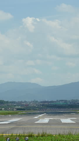 4K Vertical back view of airplane touching down runway with smoke