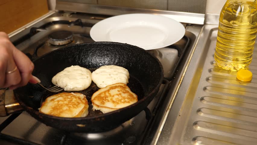 Pancakes are fried in a pan. Cooking pancakes