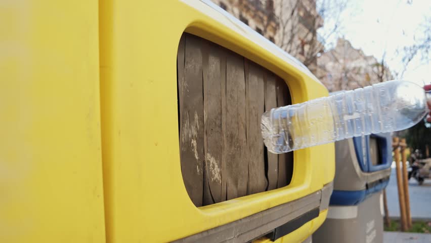 Close-up of hand throwing empty plastic bottles into recycling bin. High quality 4k footage