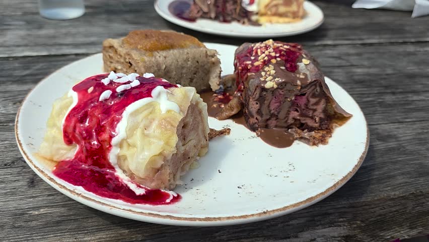 Traditional Slovenian Štruklji dumplings served with sweet toppings. Authentic homemade dessert dish captured in close-up on a rustic wooden table.