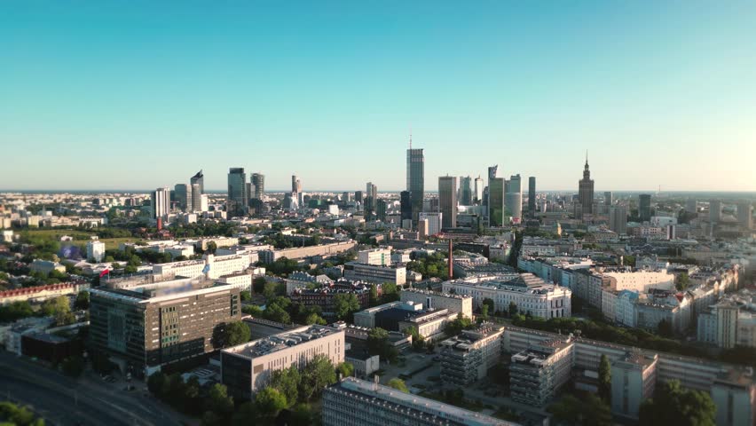 Aerial view of Warsaw cityscape featuring a mix of modern skyscrapers and historic buildings under a clear sky, capturing the vibrant urban life of Poland capital, 4k footage