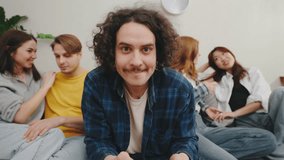 While two couples embrace on the couch, a cheerful man plays with a game controller, fully immersed and content to be alone in a cozy, modern living room - Powered by Shutterstock - Get 15% off with code: PIKWIZARD15