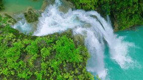 Aerial view of the Agua Azul waterfall, with turquoise water cascading over limestone formations surrounded by lush green jungle foliage, Mexico. - Powered by Shutterstock - Get 15% off with code: PIKWIZARD15