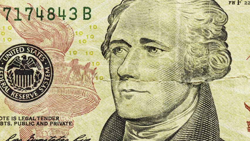 Close pan of a modern U.S. ten dollar note showing portrait and center crease