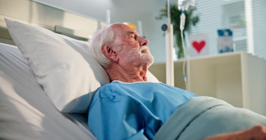Senior man, patient and sleep on hospital bed for recovery, post surgery and anesthesia. Sick, elderly person and nap with iv drip for healthcare service, asleep and treatment healing from operation