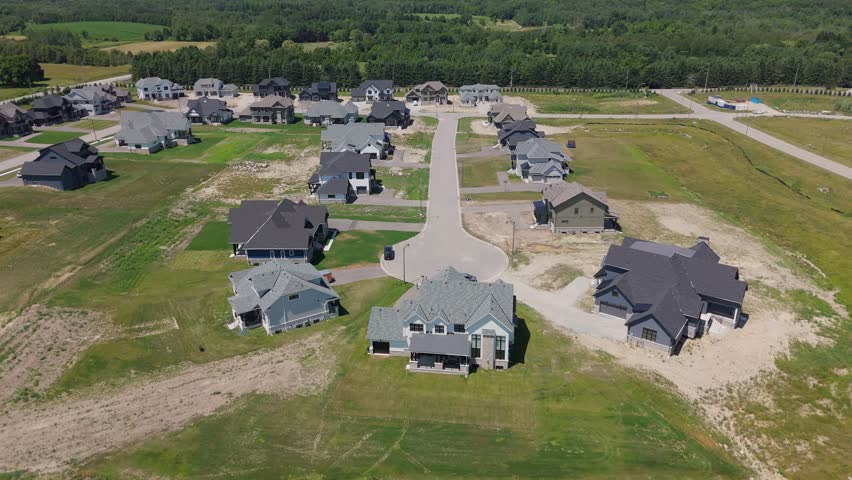 Large houses in newly built neighborhood by nature in Canada, drone push-in