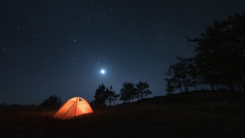 Timelapse of Night Galaxy Stars and Moonset Over The Camping Tent in forest