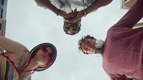 View from behind of three multiethnic gen Z peers in sunglasses, young woman with tattoos and piercing and two men, looking at camera and gesturing on city street - Powered by Shutterstock - Get 15% off with code: PIKWIZARD15