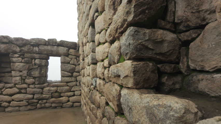 Slow motion video of Inca stone structures inside Machu Picchu, showing ancient walls and architecture in Peru