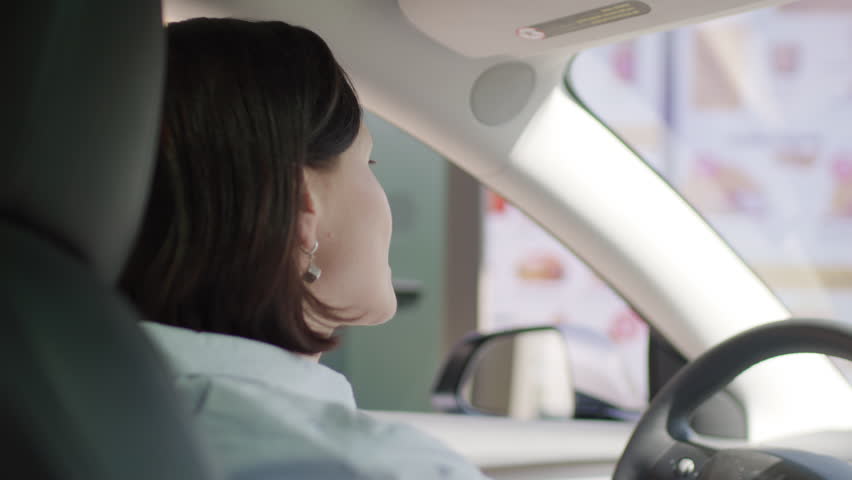 Woman Ordering Food from Car. Drive-Thru Scene