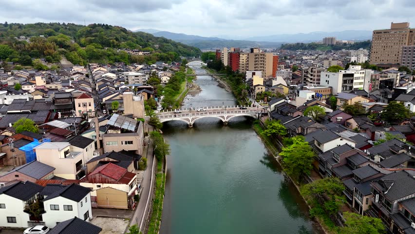 Drone video of Kanazawa, Japan, river with traffic of bridge