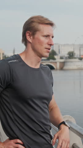 Vertical tired adult man breathing heavily while checking health app set on smartwatch