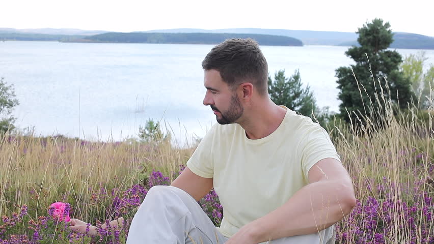Man smelling a flower in stunning natural setting 