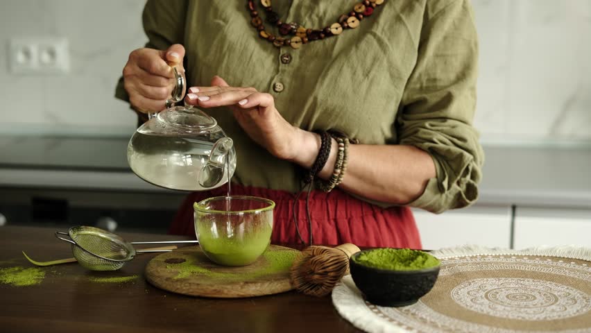 Close-Up Of A Woman Adding Water To Matcha Tea Preparation