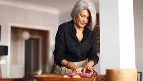 Mature woman unpacks groceries in her modern apartment, placing fresh apples on the dining table - Powered by Shutterstock - Get 15% off with code: PIKWIZARD15