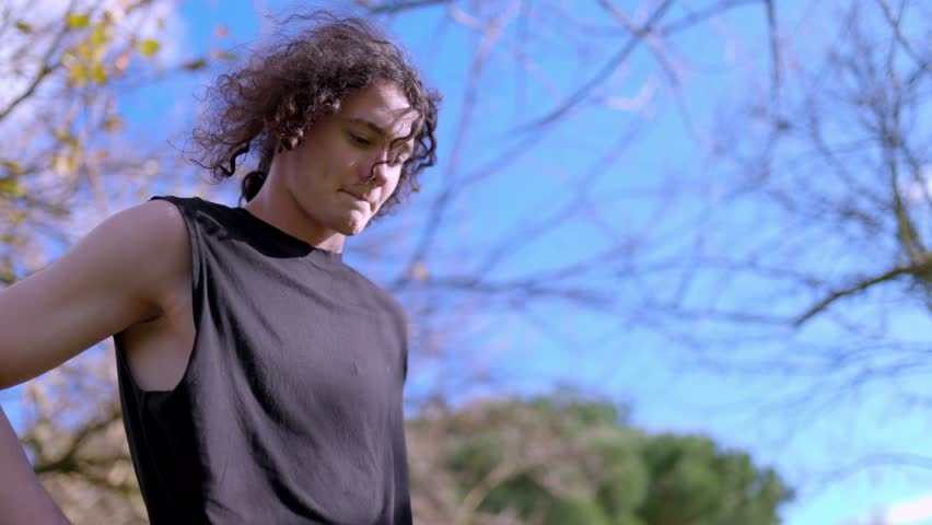 Young man performing breathing exercises in park