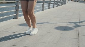 Smiling brunette woman using skipping rope to jump on promenade on summer day - Powered by Shutterstock - Get 15% off with code: PIKWIZARD15