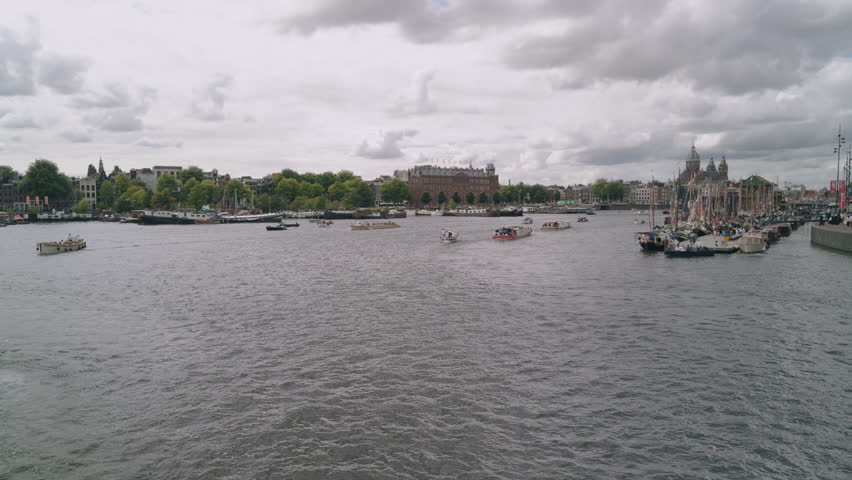 Boat ship sailing festival parade in the Netherlands, Amsterdam, wide angle view of the city town centre with sailing ships ferries and boats in European authentic style