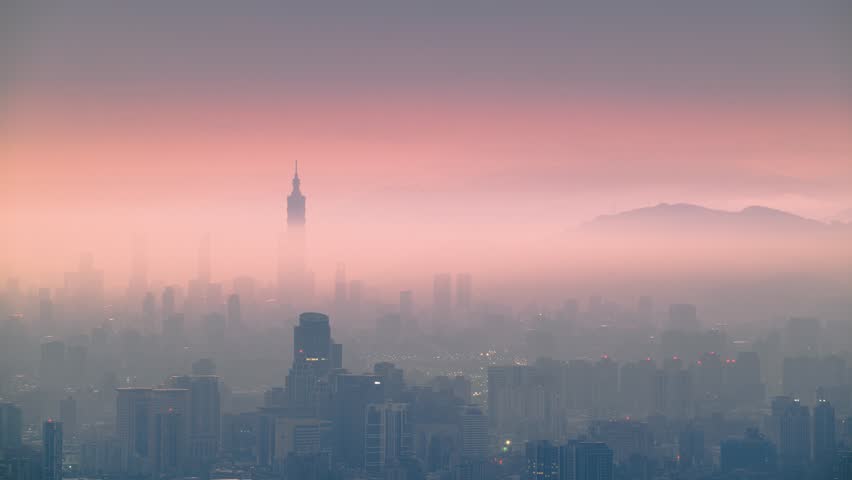 Ethereal dawn over Taipei City with Taipei 101 shrouded in orange mist from Dadao Mountain in Shulin New Taipei City Taiwan as streetlights fade.