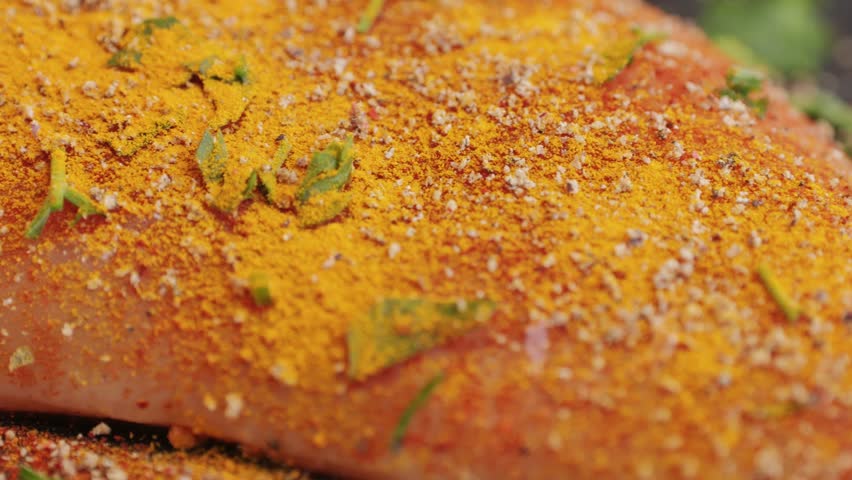 Raw chicken meat in yellow turmeric spice on plate close-up. Preparing raw food for cooking. Grilled chicken, duck, turkey kebab with vegetables.