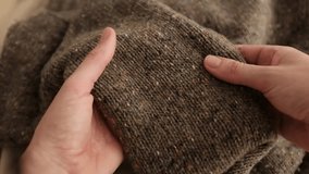 Closeup video of hands touching soft wool sweater. Brown knitted sweater for cold winter. Appreciating pleasant texture of high quality clothes. Soft and cozy clothes.  - Powered by Shutterstock - Get 15% off with code: PIKWIZARD15
