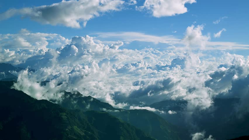 Breathtaking aerial view of rolling clouds over Hehuan Mountain, Taiwan during a clear autumn day. Lush green mountain ranges under a vibrant blue sky.