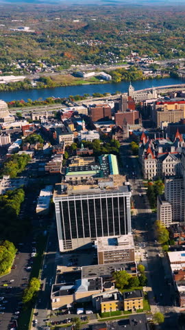 Aerial view of the city of Albany, NY in autumn. Top view of downtown office buildings with the Hudson River in the background. Vertical video.