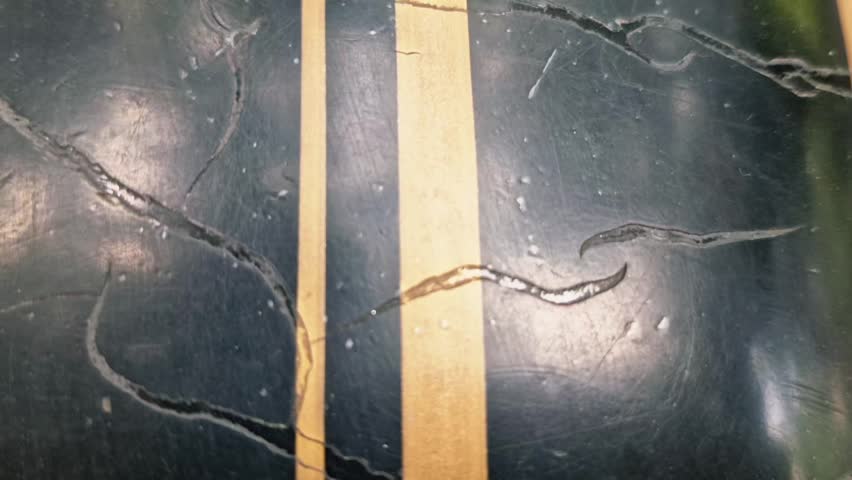 Black metal surface with a striking gold stripe, covered in numerous scrapes and scratches, creating a rugged, textured, and worn aesthetic. - Powered by Shutterstock - Get 15% off with code: PIKWIZARD15