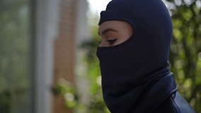 Detective girl in black outfit and mask uses flashlight to look through window while investigating a house, symbolizing secret surveillance and investigation scene. - Powered by Shutterstock - Get 15% off with code: PIKWIZARD15