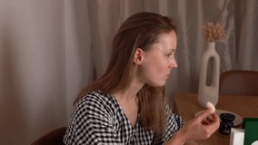 A young woman eats corn puffs in the living room, side view. Concept of fast food, snack, junk food, lifestyle, relaxation at home, unhealthy eating habits. - Powered by Shutterstock - Get 15% off with code: PIKWIZARD15