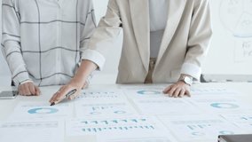 Two businesswomen examining financial data on charts and graphs during an office meeting, highlighting collaboration and strategy, close up. Business people concept - Powered by Shutterstock - Get 15% off with code: PIKWIZARD15
