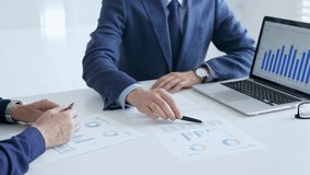 Business colleagues discussing financial data on a laptop and printed documents while analyzing charts and market trends. Business people and finance concept - Powered by Shutterstock - Get 15% off with code: PIKWIZARD15