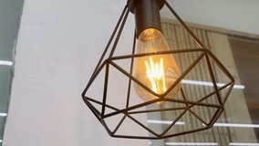 Close-up of a stylish industrial-style pendant light with an illuminated Edison bulb - Powered by Shutterstock - Get 15% off with code: PIKWIZARD15