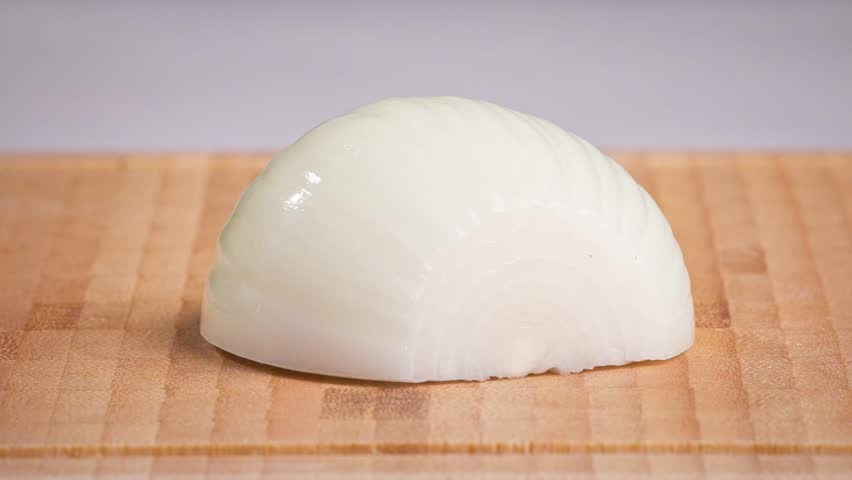 chef cut onion on cutting board with sharp knife for making healthy meal and cooking, cook cutting white juicy onions for making salad, food closeup in kitchen