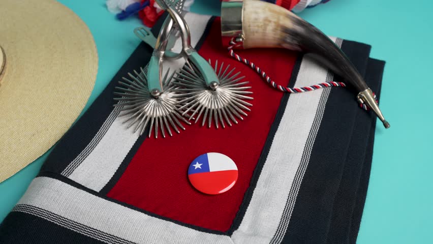 Traditional chilean huaso attire displayed with spurs, drinking horn, and chilean flag pin