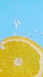 Sliced orange fruit drop underwater on blue background. Citrus freshness with splash and bubbles. Summer refreshment and juicy taste. Healthy vitamin drink and seasonal harvest moment - Powered by Shutterstock - Get 15% off with code: PIKWIZARD15