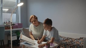 Grandmother helping grandson with homework at home - Powered by Shutterstock - Get 15% off with code: PIKWIZARD15
