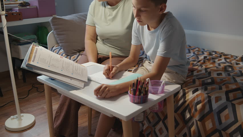 Parent helping child with homework at home