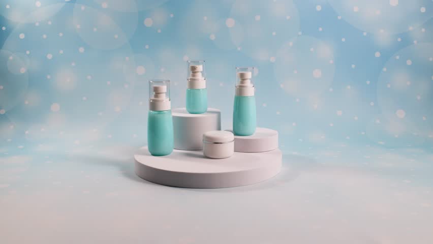 The skin care bottles are arranged on round platforms on a blue background. A video for the presentation of packaging of various products, including dropper bottles and pumps, demonstrating modern aes
