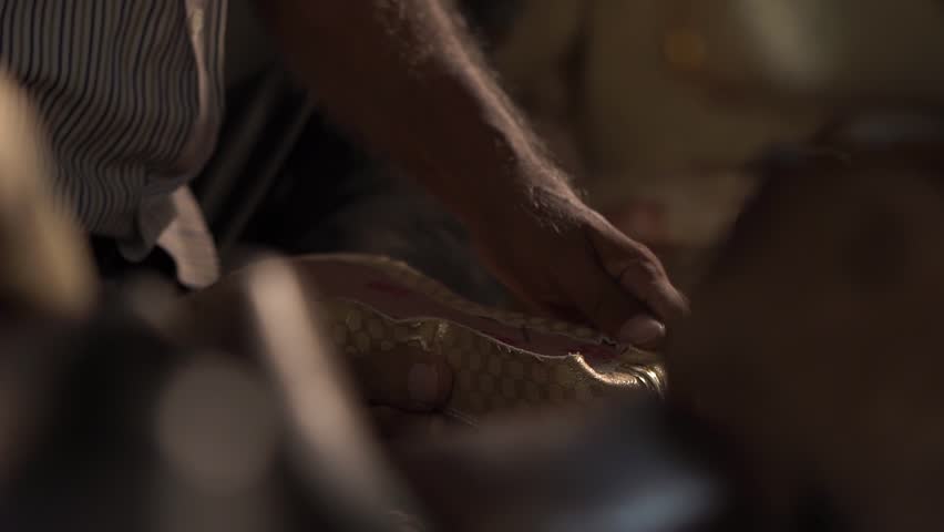 Man making traditional Indian foot wear. Indian Punjabi jutti.