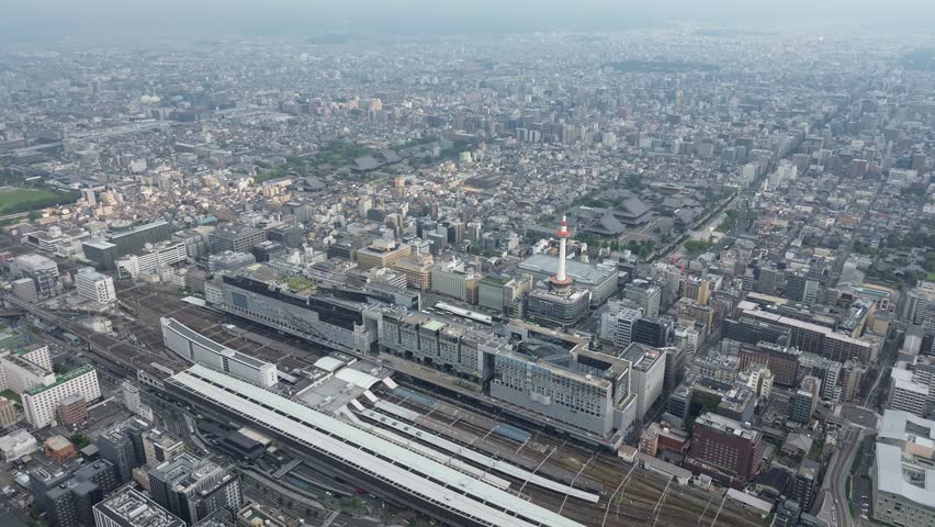 Morning cityscape of Kyoto, Japan, featuring Kyoto Tower, Kyoto Station, and surrounding modern buildings.