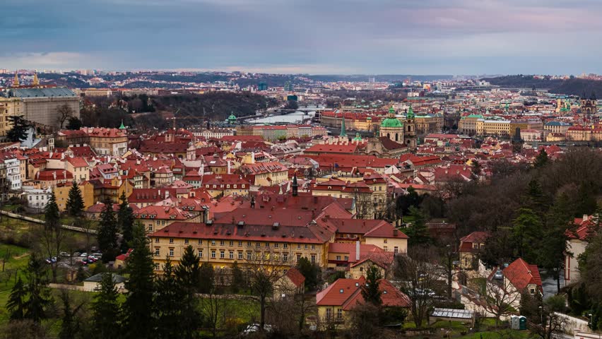Prague. Aerial view of Prague, Czech Republic during the golden hour, with the citys iconic red rooftops and green domes contrasting against the blue sky.