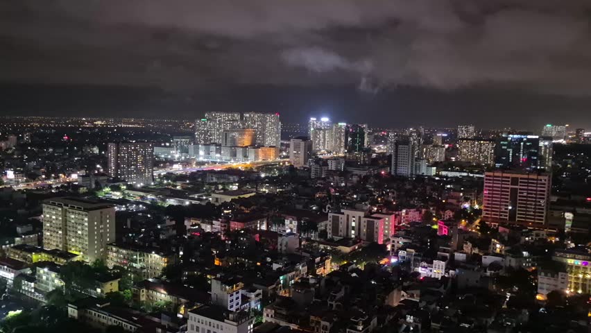 Night view of Hanoi from Cau Giay district, capturing the dazzling skyline and vibrant city lights as the camera pans across the bustling capital of Vietnam.