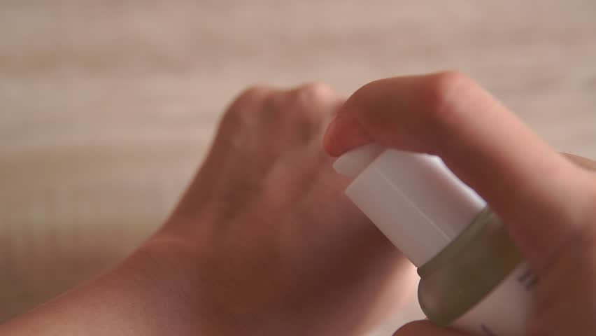 Close up footage of a woman putting a cream swatch on her hand to show the cream texture.