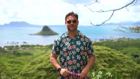 Tourist in floral shirt puts on a Hawaiian lei necklace with ocean and islands in background. Man on tropical vacation shows tradition, tourism, culture, leisure and exotic travel experience. - Powered by Shutterstock - Get 15% off with code: PIKWIZARD15